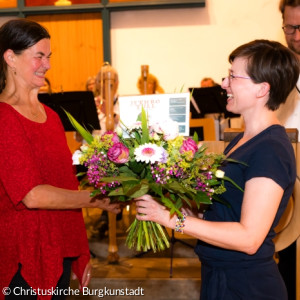 Lisa Kohles überreichte im Namen des Kirchenvorstandes Blumen und Konzertkarten an Susi Schliefer für 29 Jahre  Chorleitung